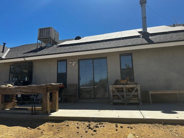 back of house featuring solar panels, a patio, and cooling unit