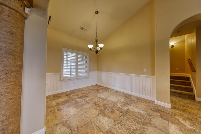 24281 Jacaranda Dr, Tehachapi, CA 93561 - unfurnished dining area with stairway, a notable chandelier, a wainscoted wall, visible vents, and arched walkways