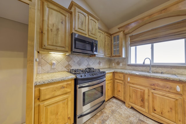 24281 Jacaranda Dr, Tehachapi, CA 93561 - kitchen featuring light stone counters, appliances with stainless steel finishes, decorative backsplash, and a sink
