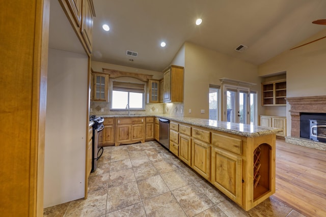 24281 Jacaranda Dr, Tehachapi, CA 93561 - kitchen with a peninsula, visible vents, light stone counters, and appliances with stainless steel finishes