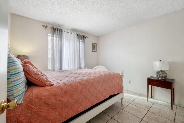 tiled bedroom featuring a textured ceiling