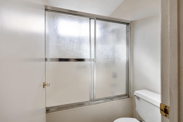 bathroom with enclosed tub / shower combo and toilet