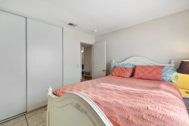 tiled bedroom featuring a closet and a textured ceiling