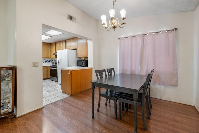 dining area with light hardwood / wood-style floors and a chandelier