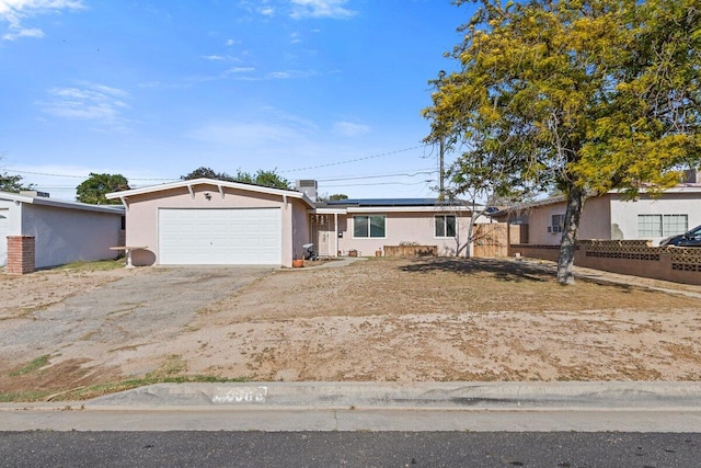 44008 E 3rd St, Lancaster, CA 93535 - ranch-style home with an attached garage, stucco siding, driveway, and solar panels