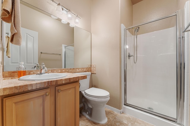 bathroom featuring tile patterned floors, vanity, toilet, and walk in shower