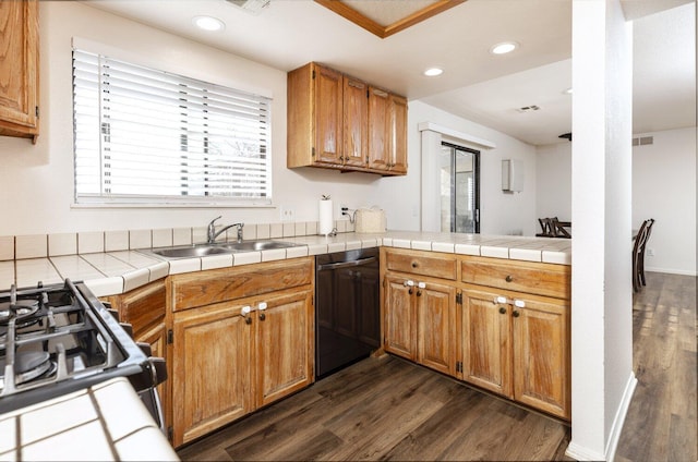 kitchen with dark hardwood / wood-style floors, tile counters, dishwasher, and sink