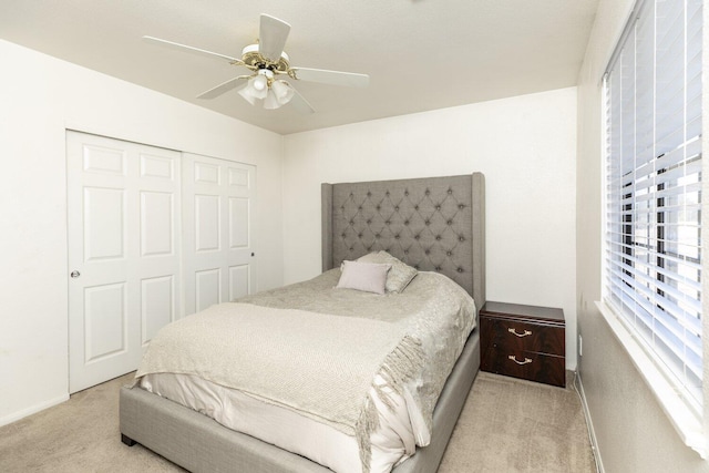 carpeted bedroom with ceiling fan and a closet