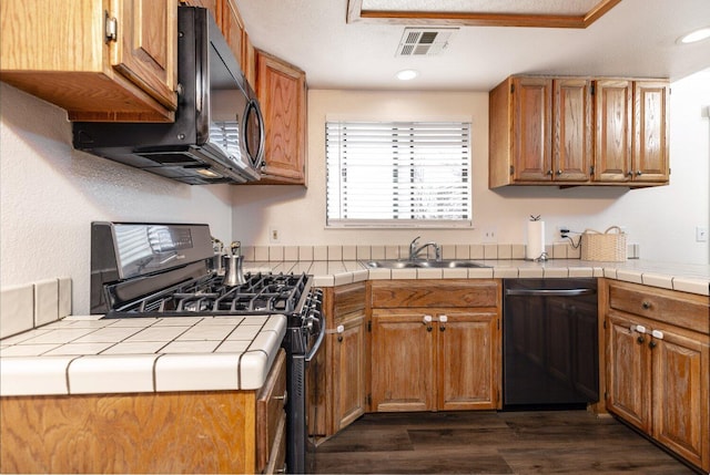 kitchen featuring sink, dark wood-type flooring, tile countertops, and black appliances