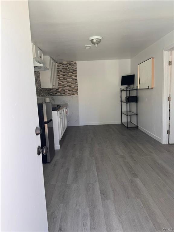 kitchen with white cabinets, wood-type flooring, and backsplash