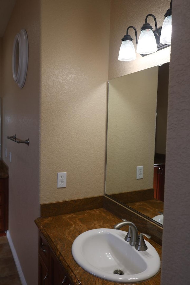 bathroom featuring vanity and a textured wall