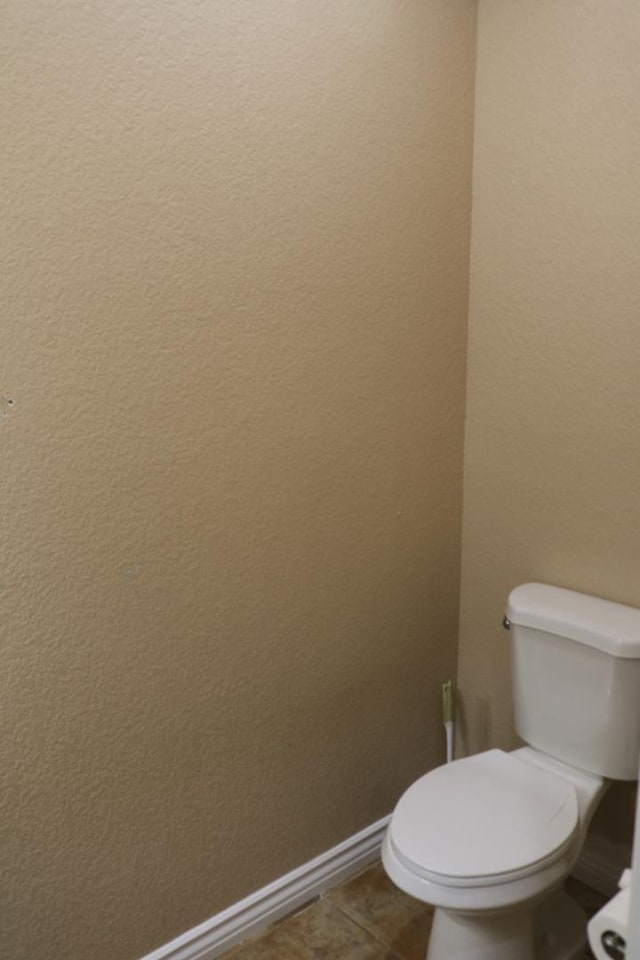 bathroom featuring tile patterned floors, baseboards, and toilet