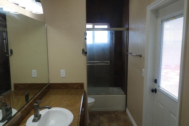 full bathroom with tile patterned floors, toilet, plenty of natural light, and enclosed tub / shower combo