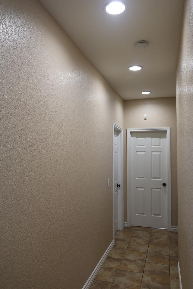 hall featuring tile patterned flooring, recessed lighting, and baseboards