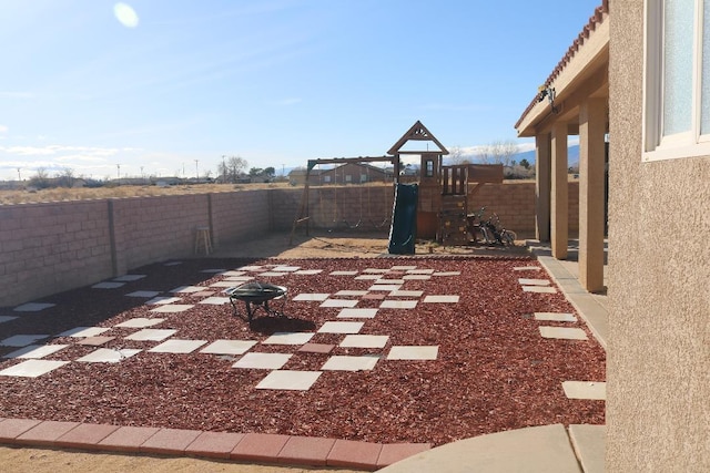 view of yard with a fenced backyard and a playground