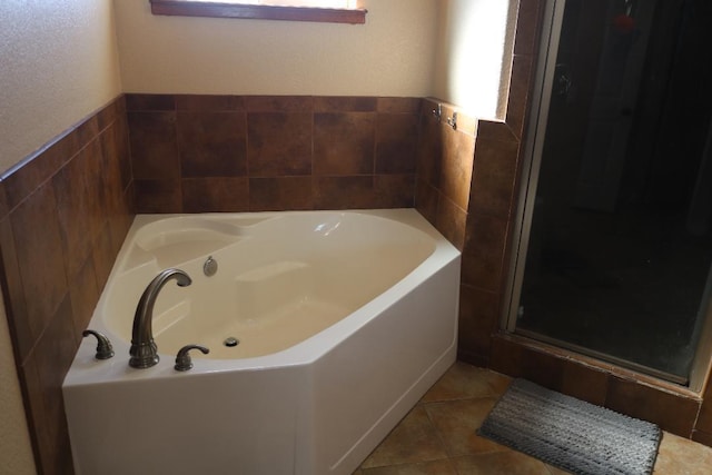 full bath with tile patterned floors, a garden tub, tile walls, and a stall shower