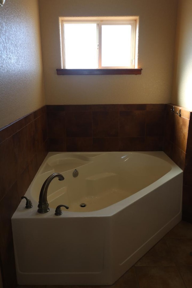 bathroom featuring tile patterned floors and a garden tub