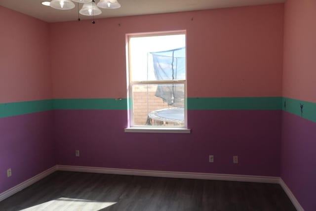 unfurnished room featuring baseboards and wood finished floors