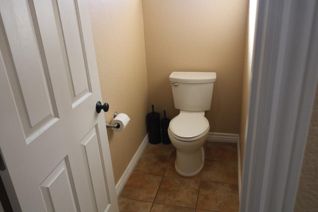 bathroom featuring tile patterned flooring, toilet, and baseboards