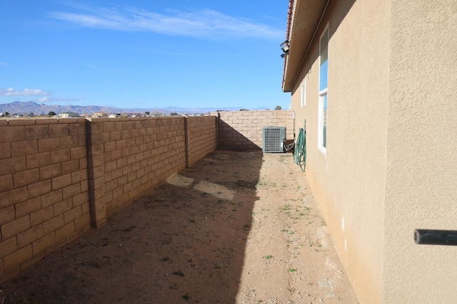 view of yard with a mountain view, cooling unit, and a fenced backyard