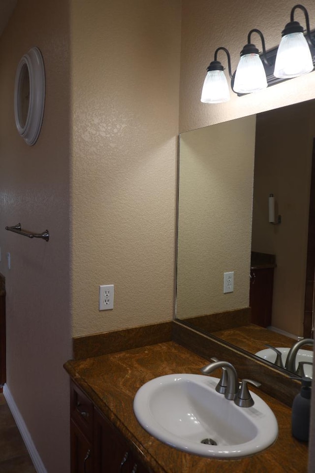 bathroom with vanity and a textured wall