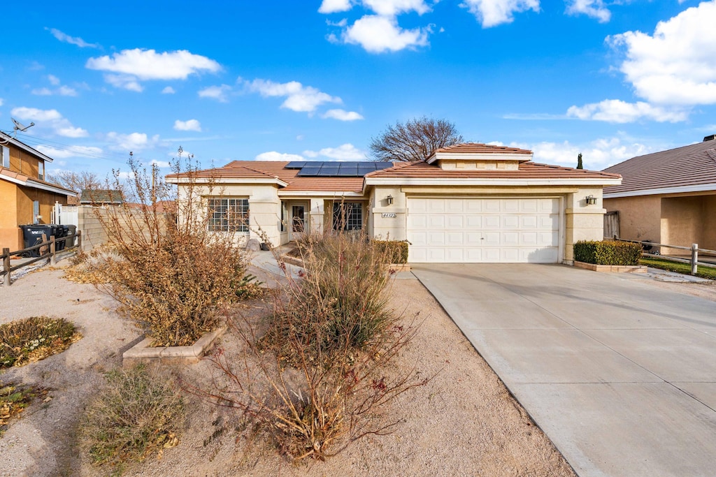 view of front of property featuring solar panels and a garage