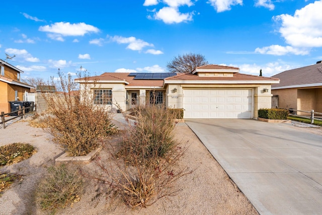 view of front of property featuring solar panels and a garage