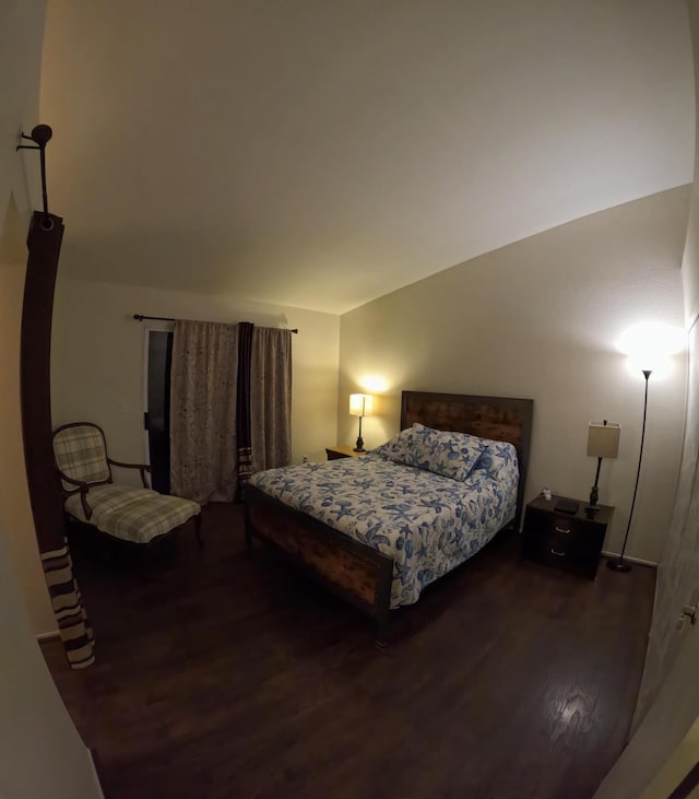 bedroom with lofted ceiling and wood finished floors