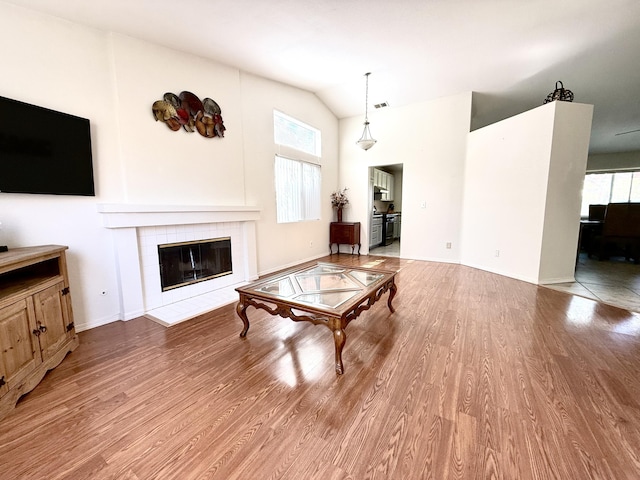 3223 Quarry Rd, Palmdale, CA 93550 - living area featuring a tile fireplace, wood finished floors, lofted ceiling, and baseboards