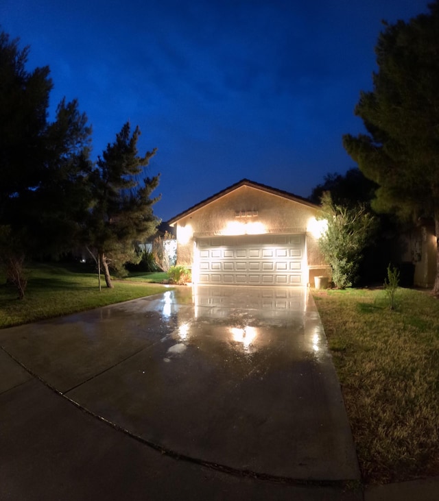 view of front of house featuring driveway, an attached garage, and a lawn