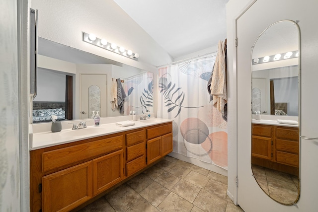 bathroom with double vanity, lofted ceiling, a sink, and a shower with shower curtain