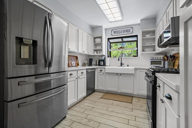 30140 Brassie Ct, Tehachapi, CA 93561 - kitchen featuring stainless steel appliances, open shelves, a sink, light countertops, and decorative backsplash