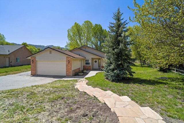 30140 Brassie Ct, Tehachapi, CA 93561 - ranch-style house with brick siding, an attached garage, asphalt driveway, and a front yard