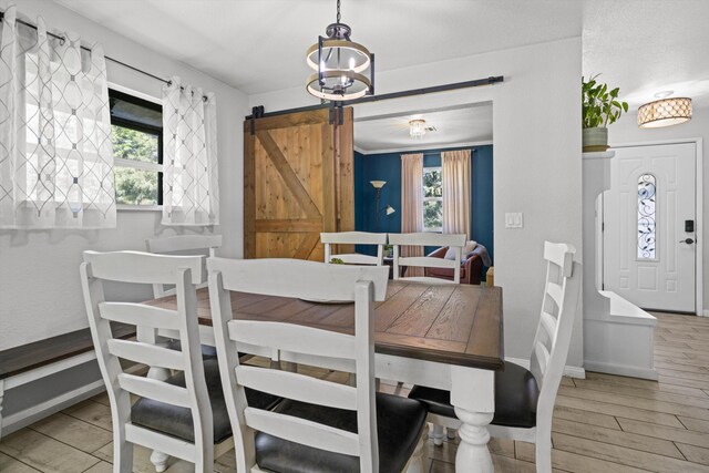 30140 Brassie Ct, Tehachapi, CA 93561 - dining area featuring healthy amount of natural light, baseboards, a barn door, and light wood-style floors