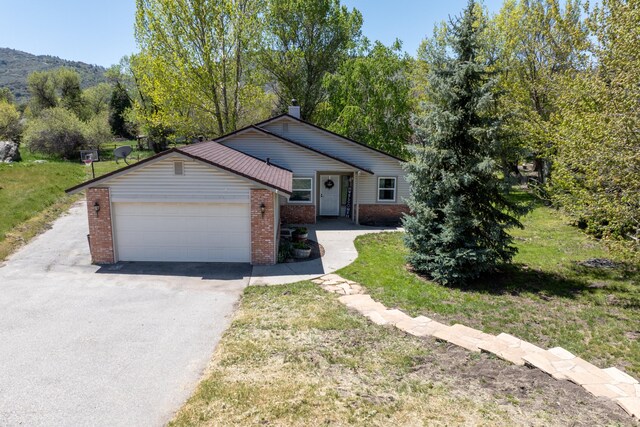 30140 Brassie Ct, Tehachapi, CA 93561 - ranch-style home with driveway, brick siding, an attached garage, and a front yard