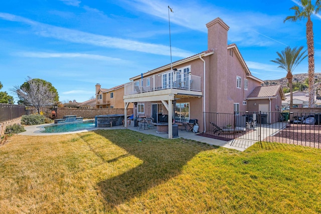 rear view of property with a yard, pool water feature, a patio, a balcony, and a fenced in pool