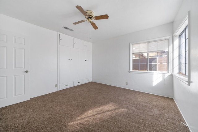 unfurnished bedroom featuring visible vents, a closet, ceiling fan, and carpet