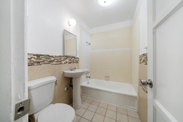 full bathroom with tile patterned flooring, tile walls, toilet, a wainscoted wall, and shower / bathtub combination