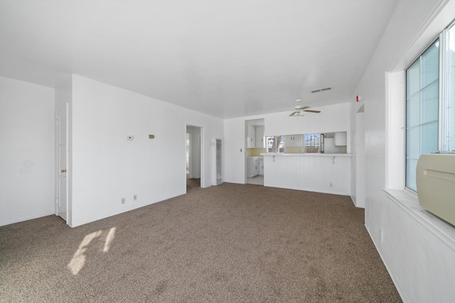 unfurnished living room featuring ceiling fan, visible vents, and light carpet