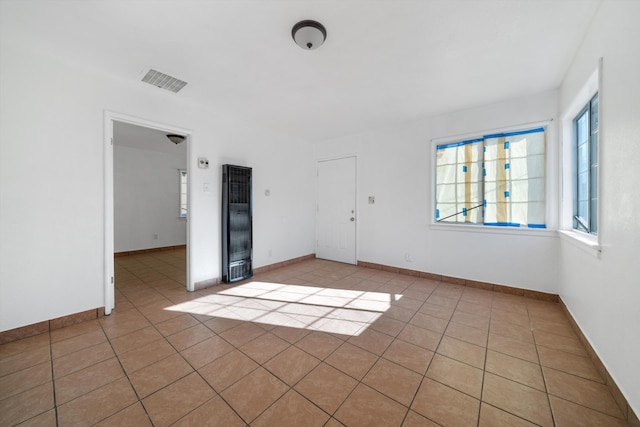 spare room featuring baseboards, visible vents, and light tile patterned floors