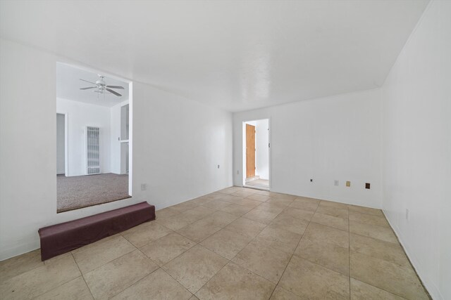 spare room with ceiling fan and tile patterned flooring