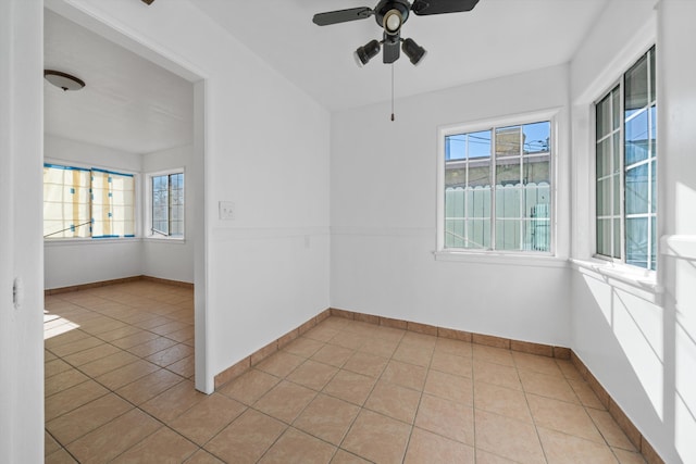 unfurnished room featuring light tile patterned flooring, ceiling fan, and baseboards