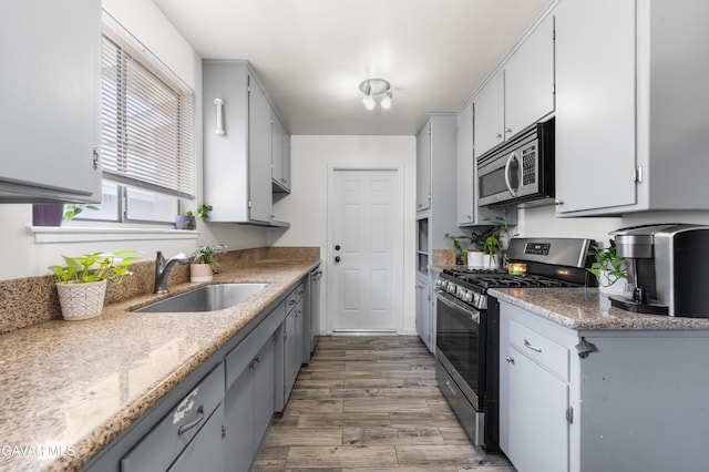 44049 Elm Ave, Lancaster, CA 93534 - kitchen with appliances with stainless steel finishes, wood finished floors, and gray cabinetry