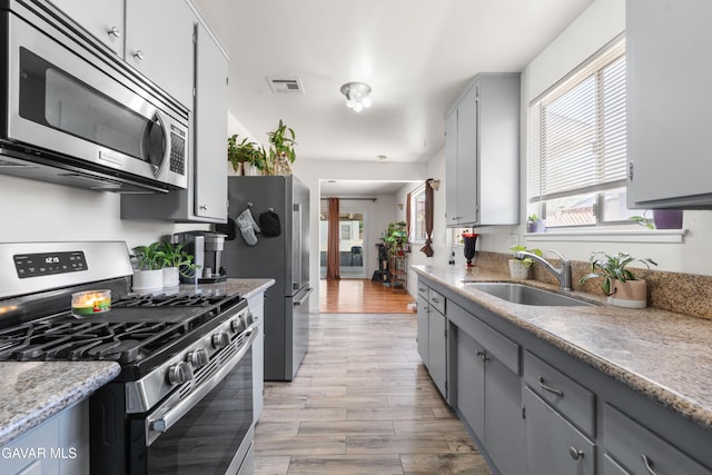 44049 Elm Ave, Lancaster, CA 93534 - kitchen with appliances with stainless steel finishes, gray cabinets, and light wood-style floors