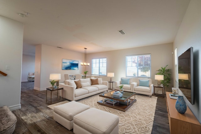 living room with dark hardwood / wood-style flooring and an inviting chandelier