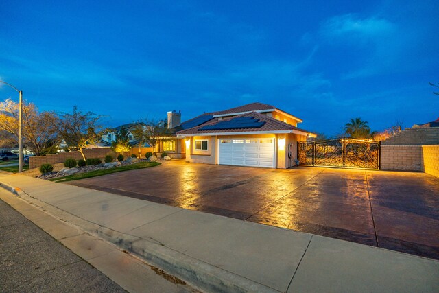 view of front facade with a gate, fence, driveway, and an attached garage