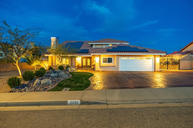 view of front facade with a garage, fence, concrete driveway, and stucco siding