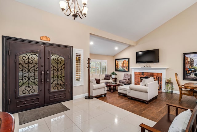 foyer featuring a brick fireplace, baseboards, a chandelier, and dark wood-type flooring