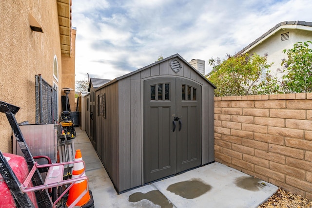 view of shed featuring fence