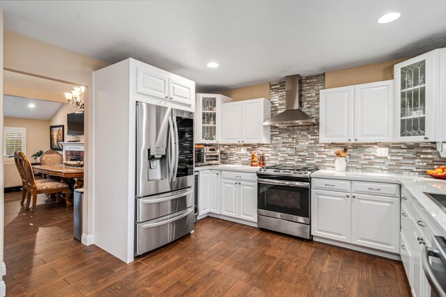 kitchen with stainless steel appliances, wall chimney range hood, dark wood finished floors, and tasteful backsplash